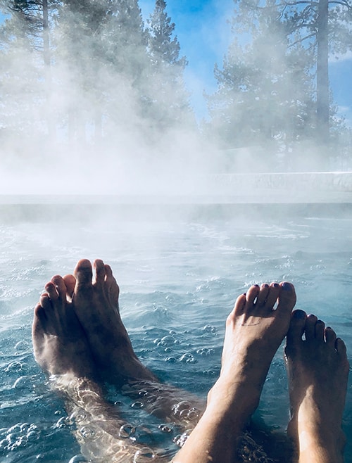 Paar streckt Füße aus dem warmen Thermalwasser der Therme Loipersdorf